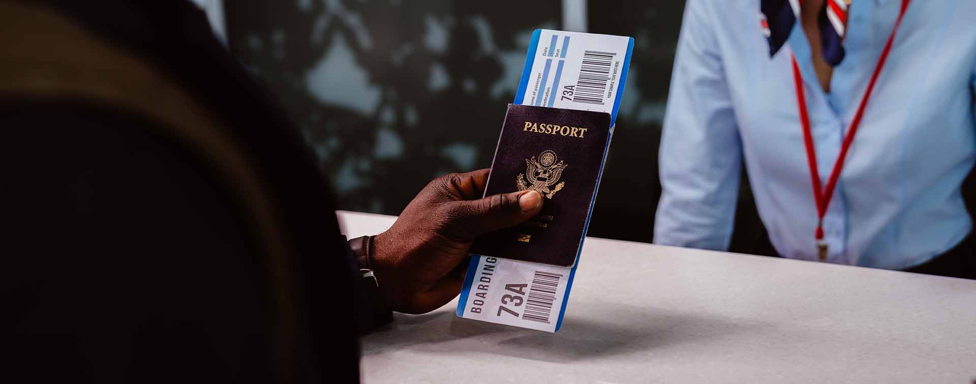Traveler holding passport and boarding pass at an airport check-in counter
