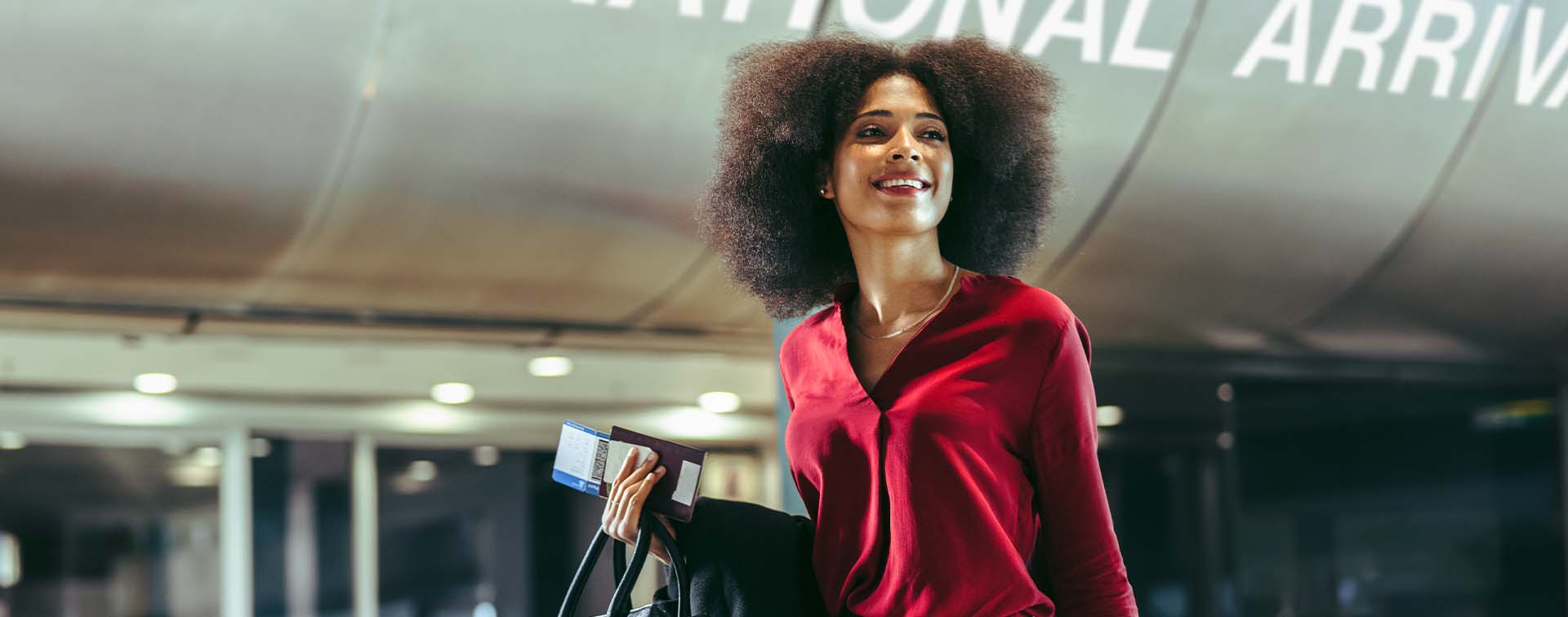 Woman in red blouse walking through international arrivals