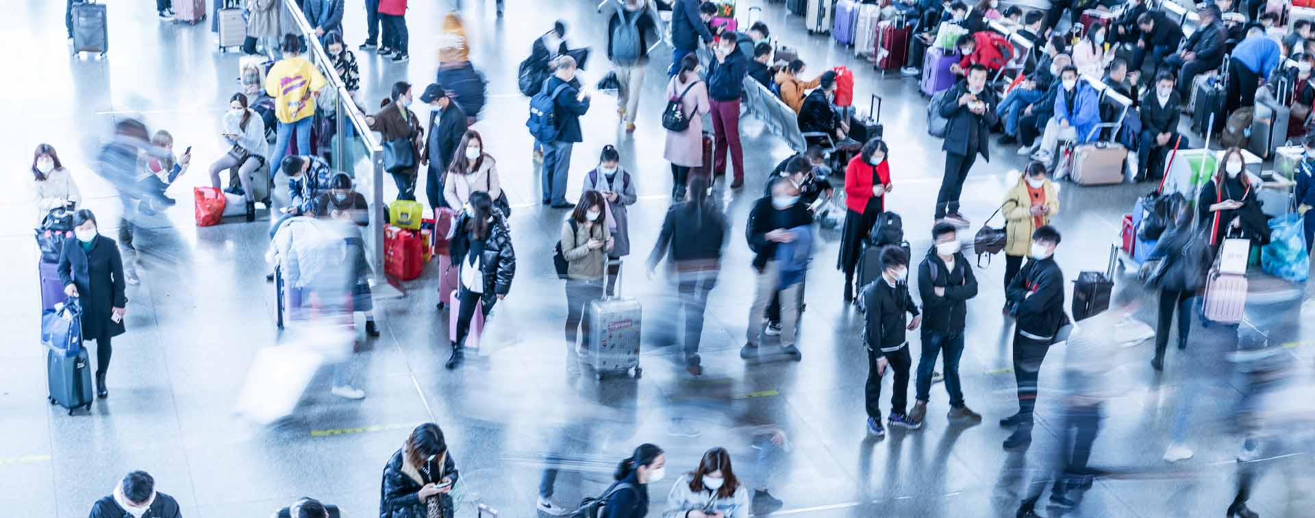 Top-down view of people in blurry movement or waiting in an aiport with luggage.