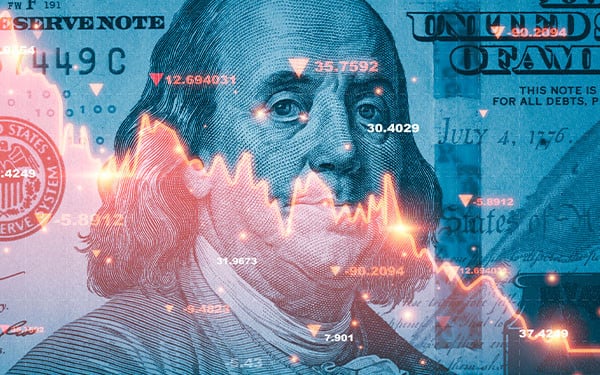 Close-up of USD 100 bill with declining red graph over it