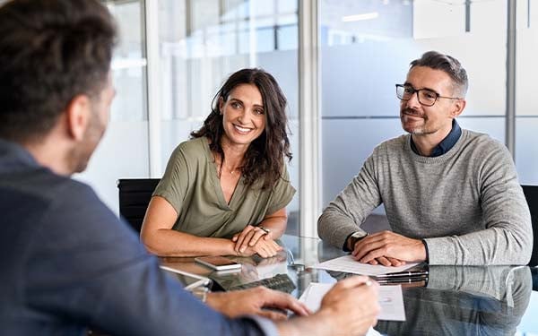 Smiling couple at a table listening to an expert