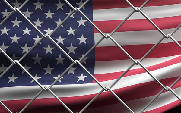 US flag behind wire mesh fence