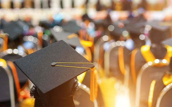 University students at graduation with bright backlighting