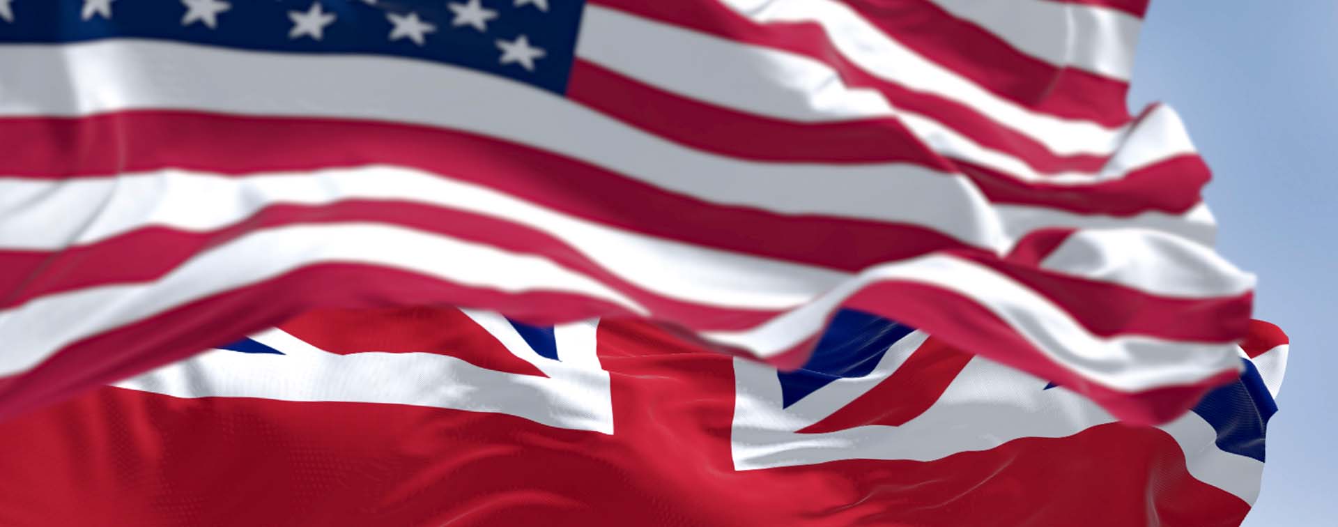 National flag of the Unites States and United Kingdom waving in the wind