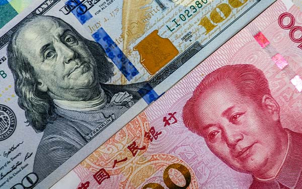 Face to face of US dollar banknote and China Yuan banknote